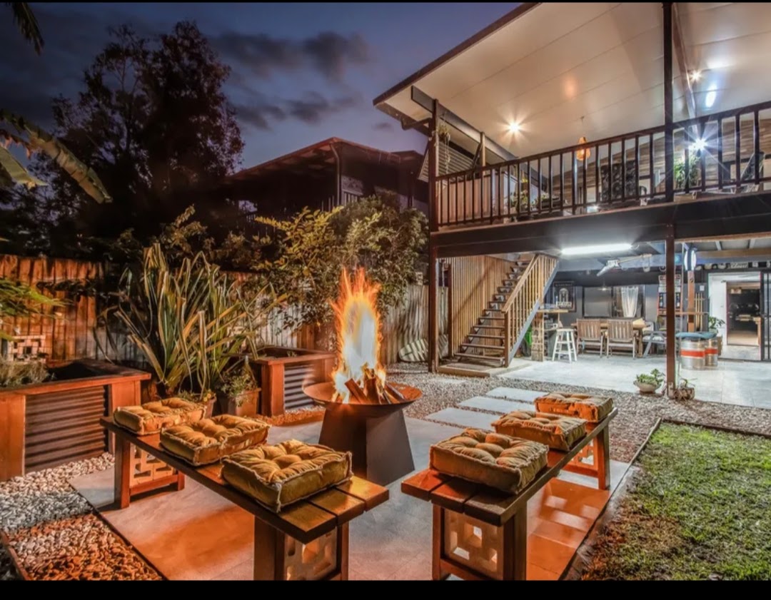 Backyard at dusk with a fire pit, bench seating and an elevated deck with stairs
